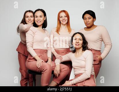 Groupe de femmes souriantes uniques de différentes races et personnages posant pour poster publicitaire Banque D'Images