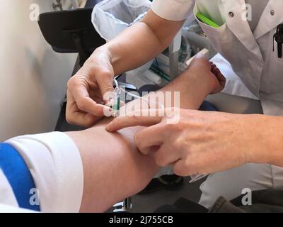Mains du médecin ou de l'infirmière utilisant une seringue à aiguille prélever un échantillon de sang du bras du patient avec une seringue. Concept de soins de santé. Gros plan. Banque D'Images