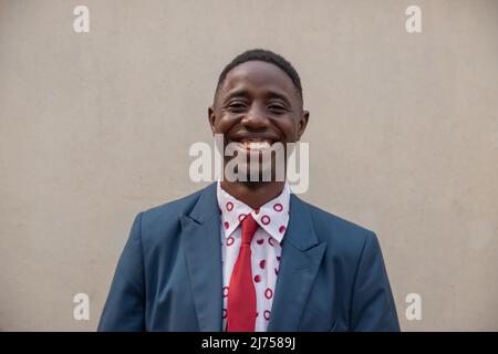 Jeune homme souriant isolé, portrait d'un homme d'affaires africain élégant Banque D'Images