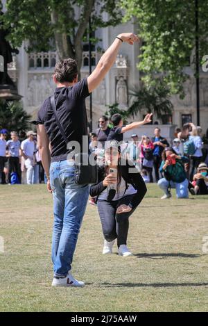 Londres, Royaume-Uni, 06th mai 2022. Les gens posent sur la place du Parlement. Les touristes raides semblent retourner à Londres avec des voyageurs individuels, des groupes guidés et des visites tous vus à pied et à vélo autour des rues, places et parcs de Westminster aujourd'hui, dans le beau soleil et les températures chaudes. Les industries britanniques du tourisme ont connu des périodes difficiles à travers la pandémie, l'économie de Londres dépendant particulièrement des visiteurs. Banque D'Images