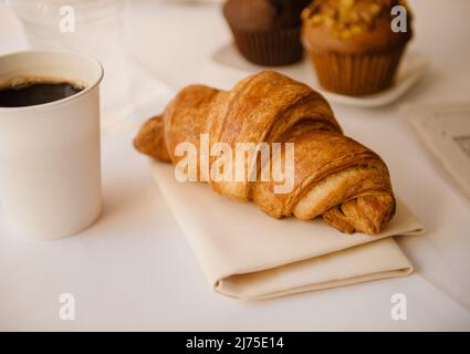 croissant avec café et muffins au petit déjeuner en arrière-plan Banque D'Images