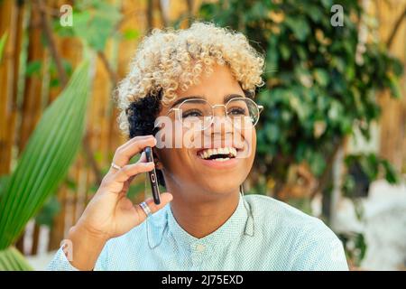 jolie fille américaine d'afrique appelant l'itinérance à la jungle de tanzanie dans le café tropical à l'ami Banque D'Images