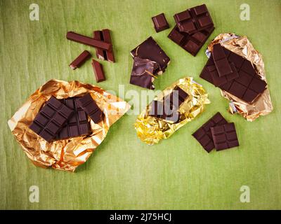 Assortiment de barres de chocolat sur le vert; emballages Banque D'Images