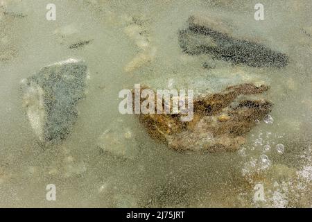 Rochers submergés sous la surface d'un lac gelé près du col de haute altitude de Shingo la dans la région himalayenne de Zanskar en Inde. Banque D'Images