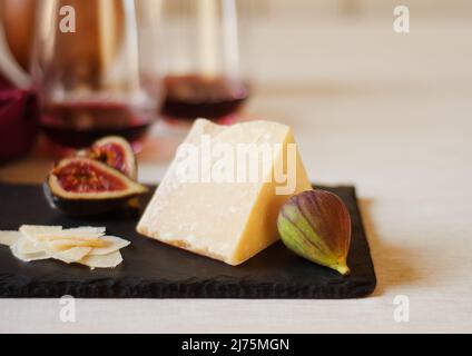 Fromage au lait de mouton vieilli avec figues sur l'ardoise ; verres de vin rouge Banque D'Images