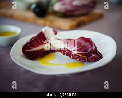 Deux feuilles de radicchio sont égoutées d'huile d'olive Banque D'Images