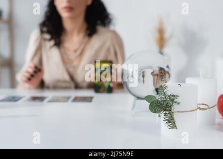 Vue rognée des bougies et orbe près de flous fortune teller à la maison Banque D'Images