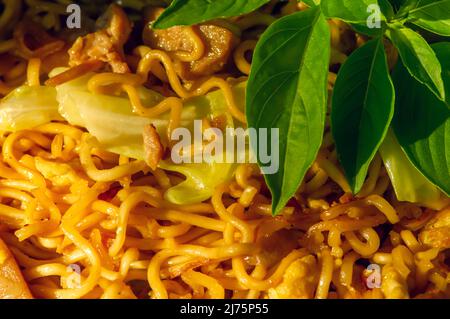 Gros plan de Mie goreng ou de nouilles frites servies avec du poulet et des légumes Banque D'Images