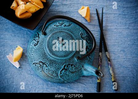 Théière asiatique bleue avec bâtonnets de thé et biscuits Fortune Banque D'Images