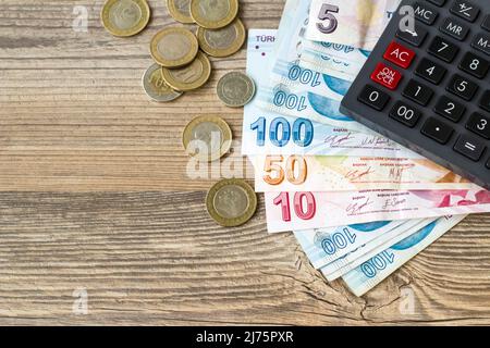 Billets, pièces et calculatrice de la Lira turque sur la surface en bois, au-dessus de la vue Banque D'Images