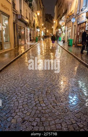 Paris, France, foule marchant, scène de rue pavée en pierre dans le centre de la vieille ville, quartier de la rue Montorgueil, la nuit après la pluie, vintafge pittoresque Banque D'Images