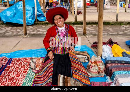 Une femme autochtone péruvienne de Quechua vendant des objets d'artisanat de Woolen au marché du dimanche dans le village de Chinchero, région de Cusco, Pérou. Banque D'Images