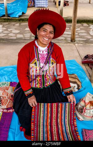 Une femme autochtone péruvienne de Quechua vendant des objets d'artisanat de Woolen au marché du dimanche dans le village de Chinchero, région de Cusco, Pérou. Banque D'Images