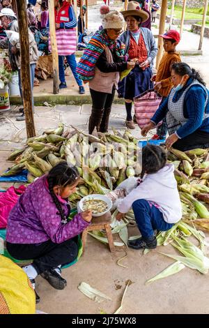 La population locale vend du maïs (Choclo) au marché du dimanche dans le village de Chinchero, la Vallée Sacrée, province d'Urubamba, Pérou. Banque D'Images