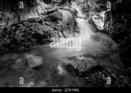 Petit ruisseau à Kesselberg près de Kochel entre les rochers dans la lumière avec de la mousse sur la pierre. Banque D'Images