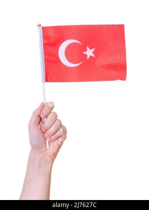 Une main tient le drapeau de la Turquie sur un fond blanc isolé. Concept du pays. Banque D'Images