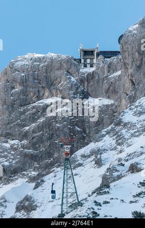 La station de montagne du Karwendelbahn en hiver avec de la neige, de la glace et des rochers durs. Une cabine sur le chemin jusqu'au bâtiment. Banque D'Images