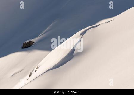 Une dune, ou vague de neige et de glace, avec de la lumière et de l'ombre sur les pentes du Karwendelspitze de Westliche au-dessus de Mittenwald sous le soleil d'hiver. Banque D'Images