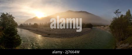 Panorama d'un virage de rivière de l'Isar près de Wallgau en début de matinée au lever du soleil avec brouillard en automne et une banque de gravier Banque D'Images