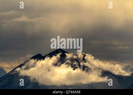 Le Soiernspitze et le groupe, photographiés du Mondscheinspitze à quelques kilomètres. Un petit nuage sous le sommet, ainsi que la brume et la pluie légère sont illuminées par le crépuscule et forment une atmosphère de lumière irréelle. Banque D'Images