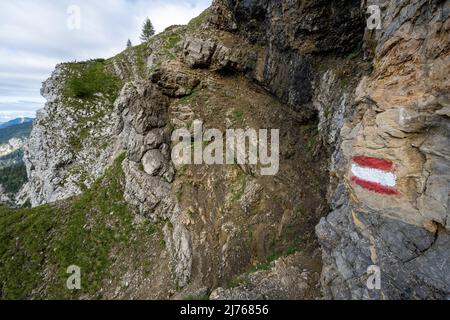 Un chemin étroit, le Gjaidsteig entre Wörnersattel et Bäralpl dans le Karwendel, en partie avec vieux câble de protection et des rochers. Un marqueur de trace indique la trajectoire. Banque D'Images