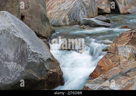Cours de la rivière Verzasca, eau qui coule à travers des rochers à bandes colorées, vallée de la Verzasca, Suisse, canton du Tessin Banque D'Images