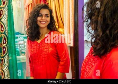 brunette femme indienne choisissant une nouvelle tradition de saree sur le marché Banque D'Images