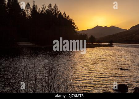 Vue classique sur Llyn Mymbyr avec le soleil couchant derrière Snowdon, parc national de Snowdonia Banque D'Images