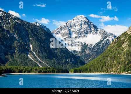 Lac entouré de forêts verdoyantes et de montagnes enneigées par une belle journée de printemps. Vue sur Thaneller. Plansee, Alpes d'Ammergau, Tyrol, Autriche, Europe Banque D'Images