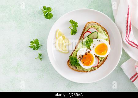 Griller avec de l'œuf dur, du radis, du concombre et du pâtés d'avocat. Vue de dessus Banque D'Images