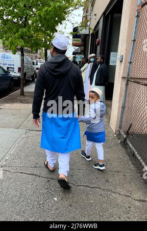 Le père et le petit fils musulmans marchent dans la mosquée locale le matin pour la prière sur Eid al Fatr après Ramadan sur Church Avenue à Brooklyn, New York. Banque D'Images