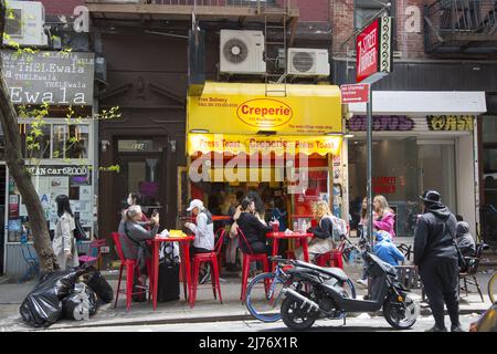 Les gens mangeant et marchant sur MacDougal Street au coeur de Greenwich Village, New York City. Banque D'Images