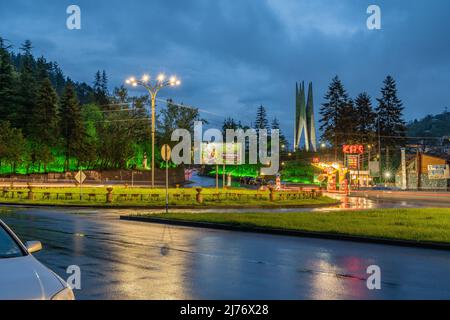 Dilijan, Arménie - 6 mai 2022 - le rond-point principal à Dilijan, Arménie la nuit après la pluie avec le monument de la guerre soviétique en arrière-plan Banque D'Images