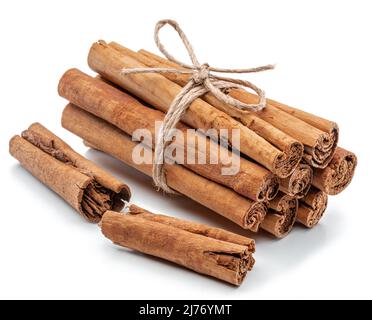 Bandelettes d'écorce séchées à la cannelle, substance brune douce à l'odeur utilisée dans la cuisson, isolées sur fond blanc. Banque D'Images