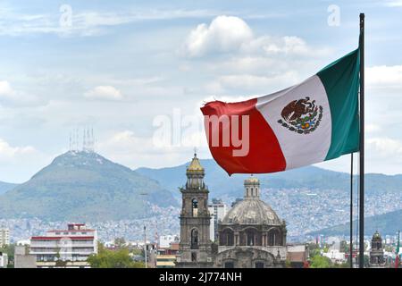 Drapeau mexicain agitant dans le vent, gros plan, centre de Mexico et église de Saint-Domingue en arrière-plan Banque D'Images