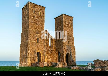 Les tours du 12th siècle dans la lumière claire tôt le matin de la ruine de l'église anglo-saxonne originale à Reculver sur la côte du Kent avec un ciel bleu clair Banque D'Images