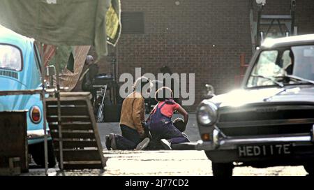 Glasgow, Écosse, Royaume-Uni 6th mai 2022. Parnie Street célèbre comme cadre principal dans le nouveau film batgirl est passé de gotham à 1970s londres pour le film Borderland un ira thriller par la magie des films. AML Ameen et Sophia Brown dans une scène où ils sont dans un magasin qu'elle peint et il est tourné par un sniper après avoir quitté les locaux qu'elle est vue tenant est tête et ils crient pour l'aide car son corps est au milieu de la route. Crédit Gerard Ferry/Alay Live News Banque D'Images