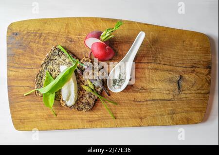 Pain de repas entier avec beurre, radis, une cuillerée de sel et d'ail sauvage sur un bois rustique, repas naturel sain, simple et délicieux, copie sp Banque D'Images