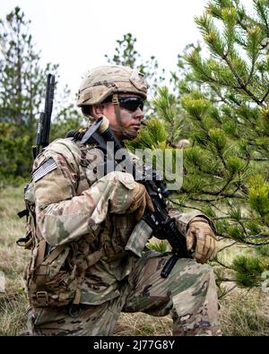 Un parachutiste de l'armée américaine affecté au 1st Bataillon, 503rd Parachute Infantry Regiment prend une pause tactique alors qu'une équipe établit un appui par position de tir pendant un exercice de tir à blanc de peloton. Cette formation fait partie de l'exercice Eagle Rapid 22 dans la zone d'entraînement de Crvena Zemlja près de Knin, en Croatie, le 6 mai 2022. L'exercice Eagle Rapid 22 est un exercice de niveau bataillon mené par le 1st Bataillon, 503rd Parachute Infantry Regiment, dans la zone d'entraînement de Crvena Zemlja près de Knin, en Croatie, du 2 au 13 mai 2022. L’objectif de cette formation est de maintenir la compétence des escadrons dans les exercices de combat par cond Banque D'Images