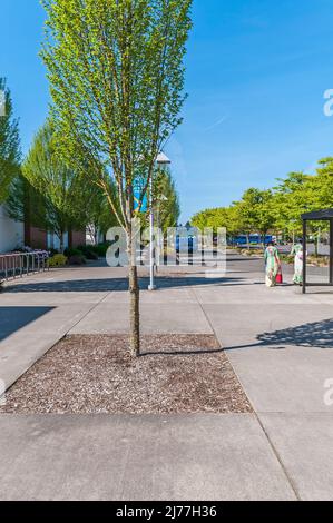 Deux femmes vêtues de robes colorées près de l'aire d'attente d'autobus sur le campus du Portland Community College à Portland, Oregon Banque D'Images