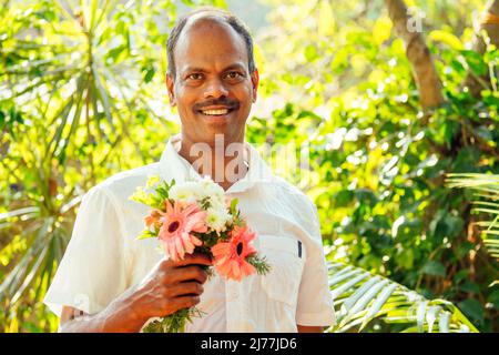 homme indien tenant un bouquet et regardant l'appareil photo Banque D'Images