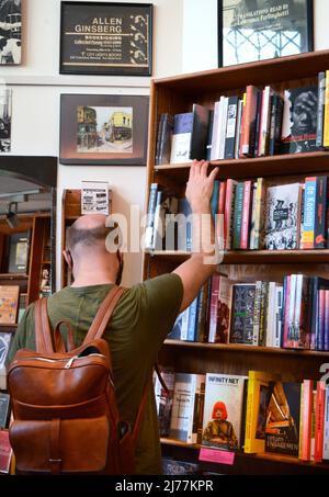 Un client utilise des étagères de livres à vendre dans la célèbre boutique City Lights Booksellers de San Francisco, en Californie. Banque D'Images