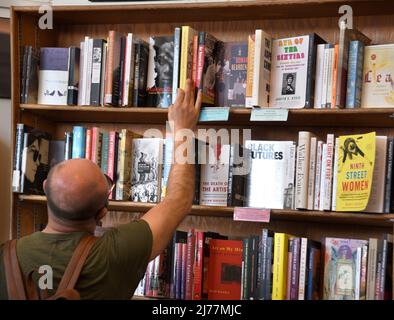 Un client utilise des étagères de livres à vendre dans la célèbre boutique City Lights Booksellers de San Francisco, en Californie. Banque D'Images