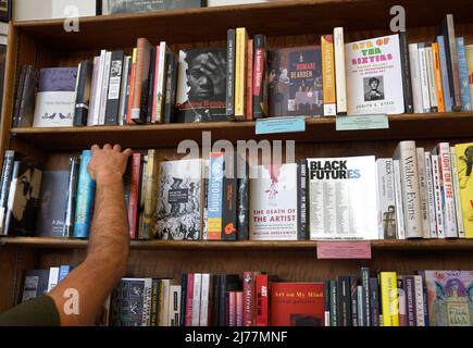 Un client utilise des étagères de livres à vendre dans la célèbre boutique City Lights Booksellers de San Francisco, en Californie. Banque D'Images