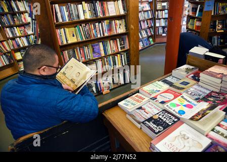 Un client utilise des étagères de livres à vendre dans la célèbre boutique City Lights Booksellers de San Francisco, en Californie. Banque D'Images