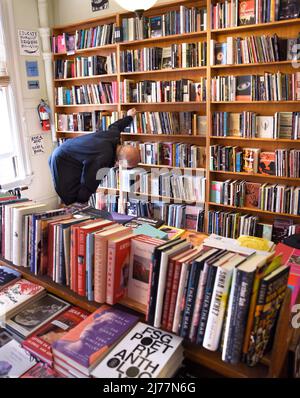 Un client utilise des étagères de livres à vendre dans la célèbre boutique City Lights Booksellers de San Francisco, en Californie. Banque D'Images