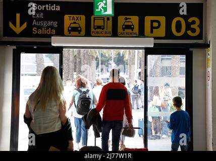 06 mai 2022, Espagne, Palma: Les personnes avec des valises marchent devant un panneau de location de voiture à l'aéroport de Palma de Majorque. Il y a beaucoup moins de voitures de location à Majorque qu'avant le début de la pandémie de Corona. Photo: Clara Margais/dpa Banque D'Images