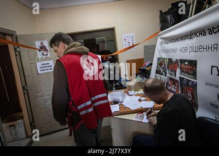 Un homme remplit un formulaire de demande de médicaments dont il a besoin au bureau de la Croix-Rouge situé à Kharkiv. Malgré les bombardements constants des troupes russes qui encerclent la ville de Kharkiv, les professionnels de la santé et les bénévoles de la Croix-Rouge ont poursuivi leurs travaux de 24/7 pour sauver des vies et aider les personnes dans le besoin. Banque D'Images