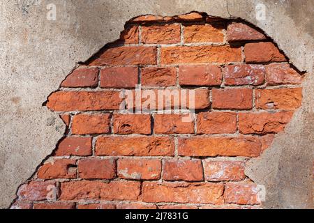 Fragment d'un vieux mur de brique avec le plâtre en fricleur gros plan Banque D'Images