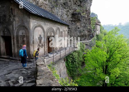 Mère et fils touristes au monastère de la grotte de Mgvimevi forgé dans la roche avec de beaux ornements, la Géorgie. Situé à proximité de la ville de Chiatura Banque D'Images